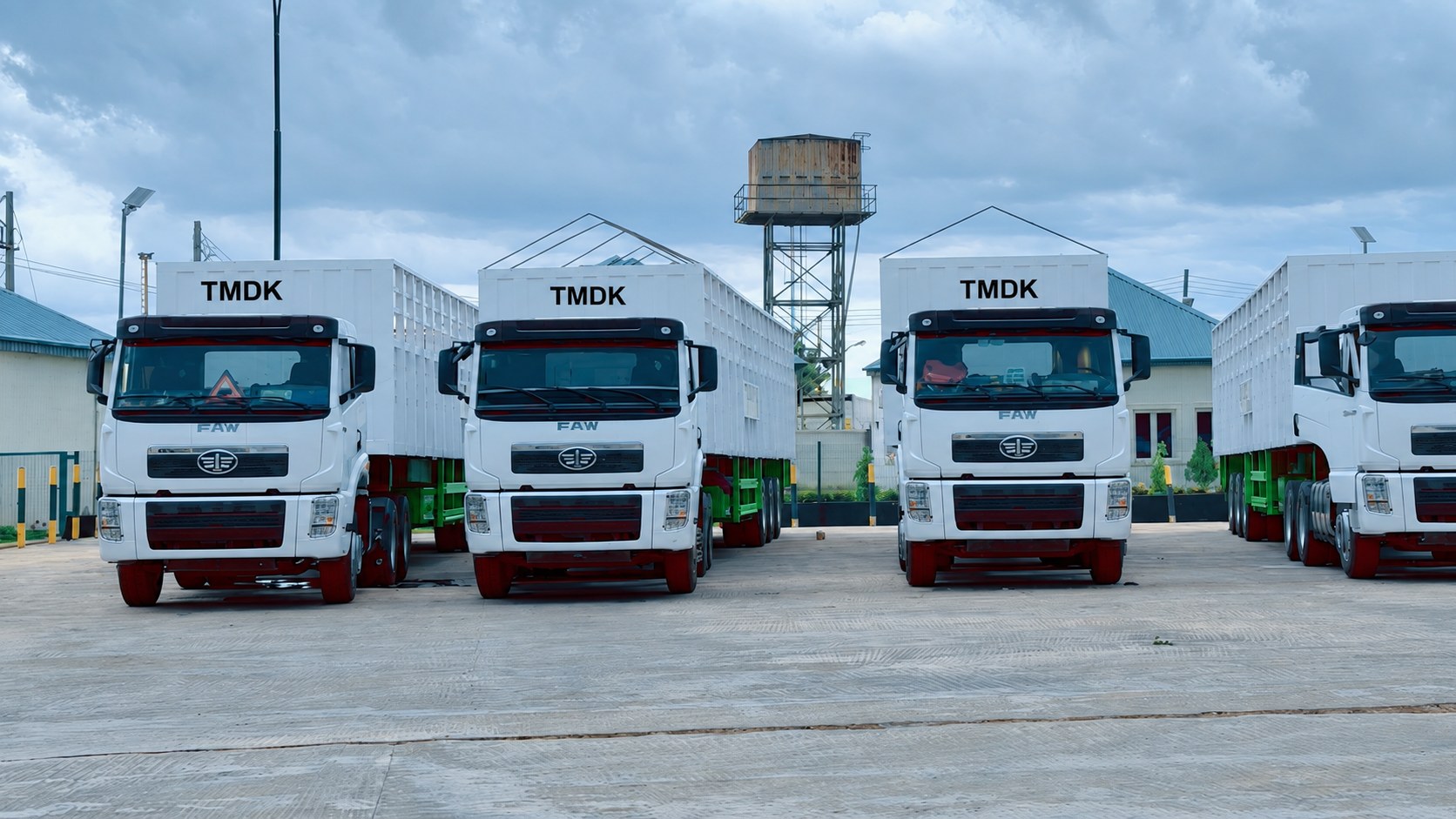 A line of TMDK branded FAW trucks parked at the Park