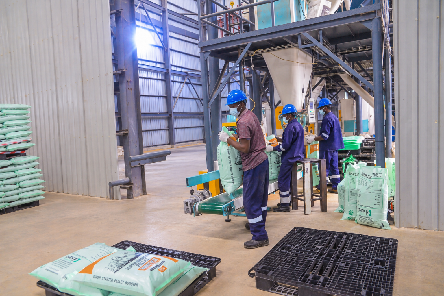 TMDK workers packing finished feed sacks on the production line