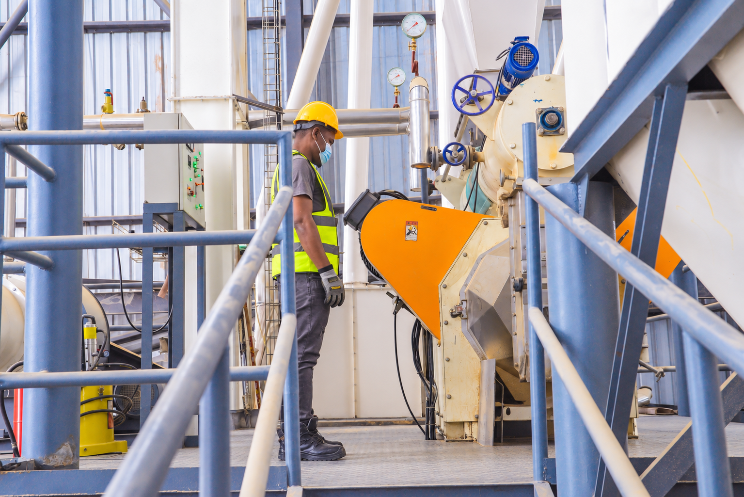 TMDK operator monitoring pelleting equipment in the feed mill
