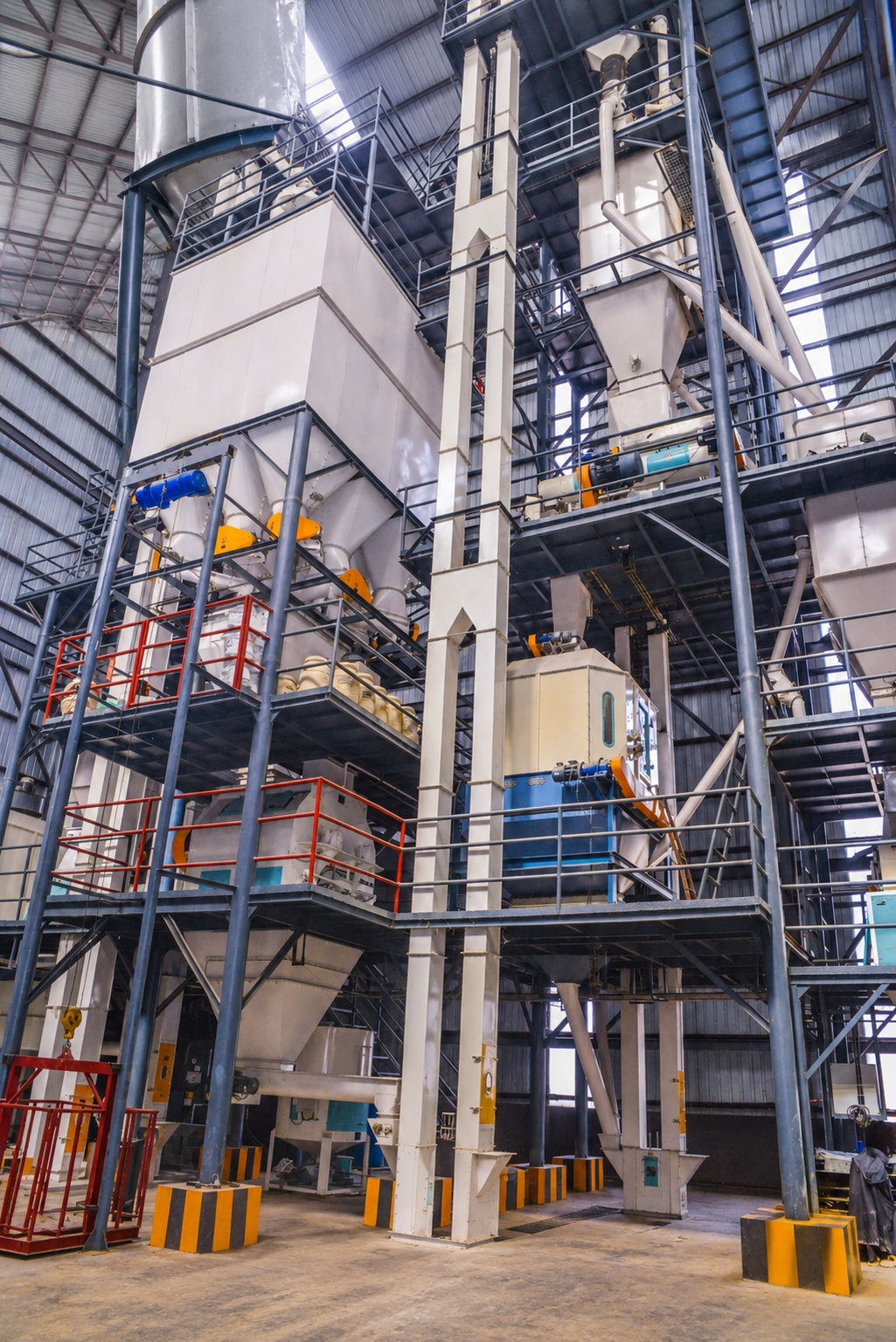 Livestock feed processing hall with mixing towers and conveyors