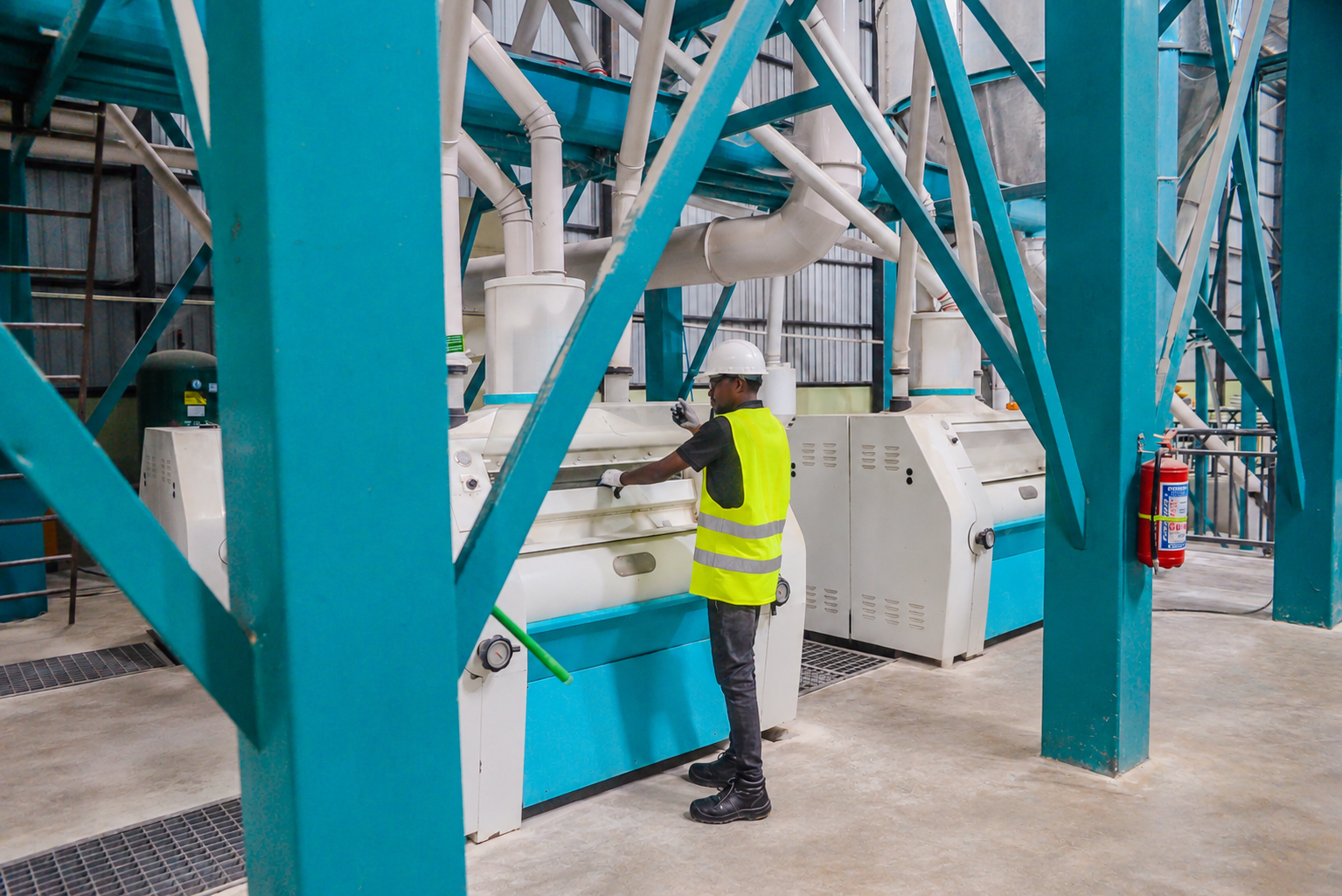 Operator at a corn milling machine inside the production hall